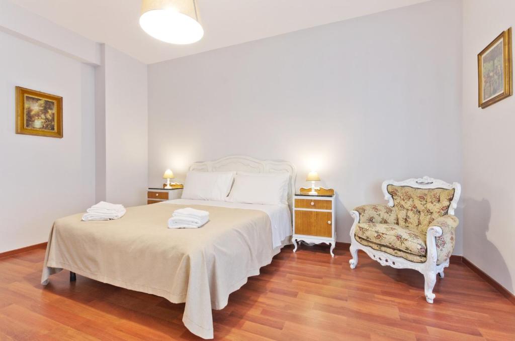 ein Schlafzimmer mit einem weißen Bett und einem Stuhl in der Unterkunft Liberty Trastevere B&B in Rom