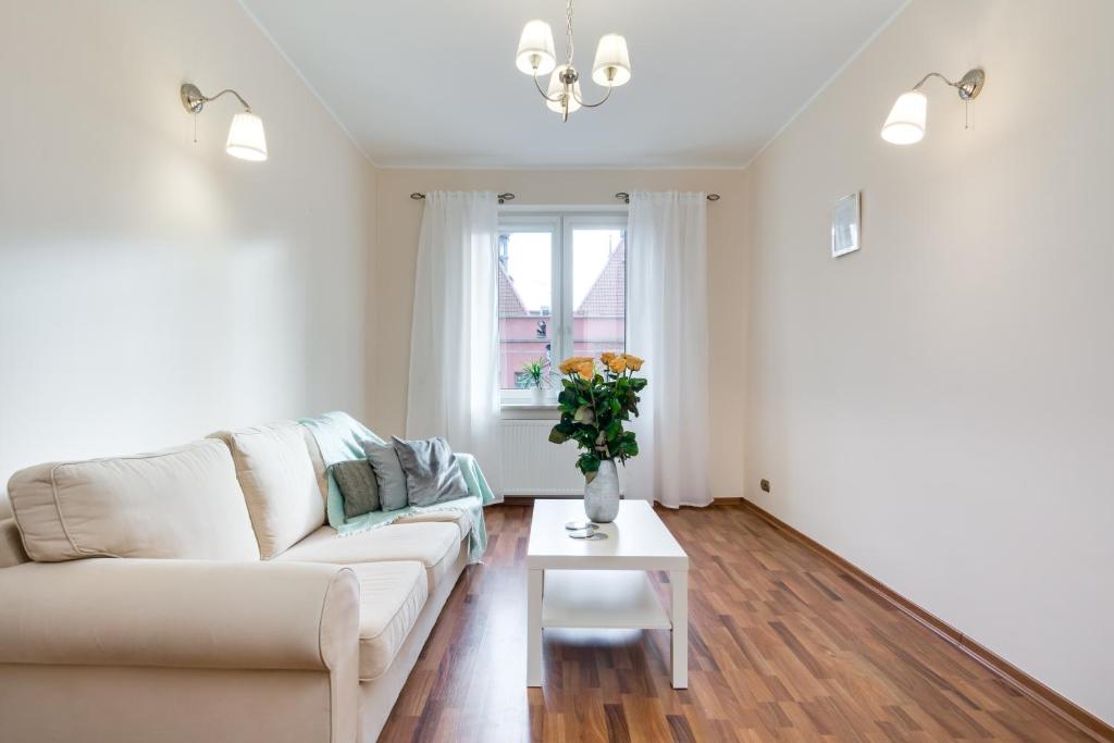 a living room with a couch and a table at Elite Apartments Korzenna City Center in Gdańsk