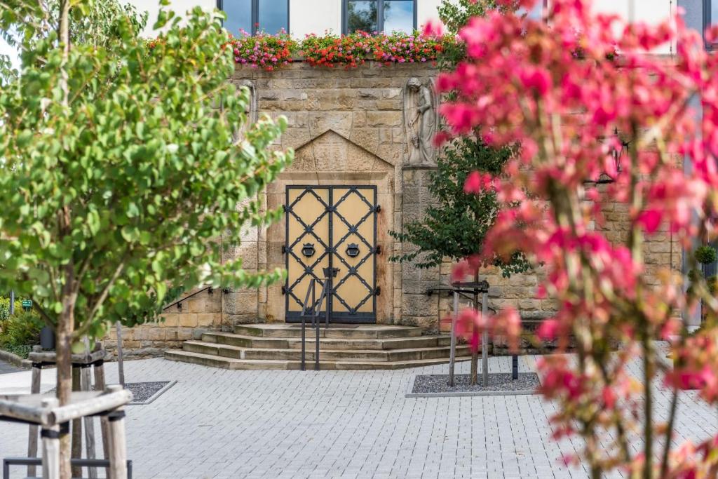 un edificio in pietra con una porta e dei fiori di Kloster Neustadt a Neustadt an der Weinstraße