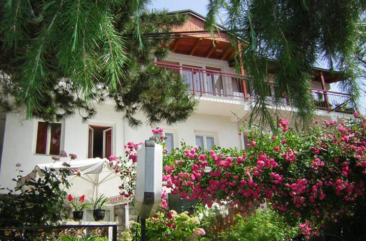 a white house with pink flowers in front of it at Bache Apartments in Ohrid