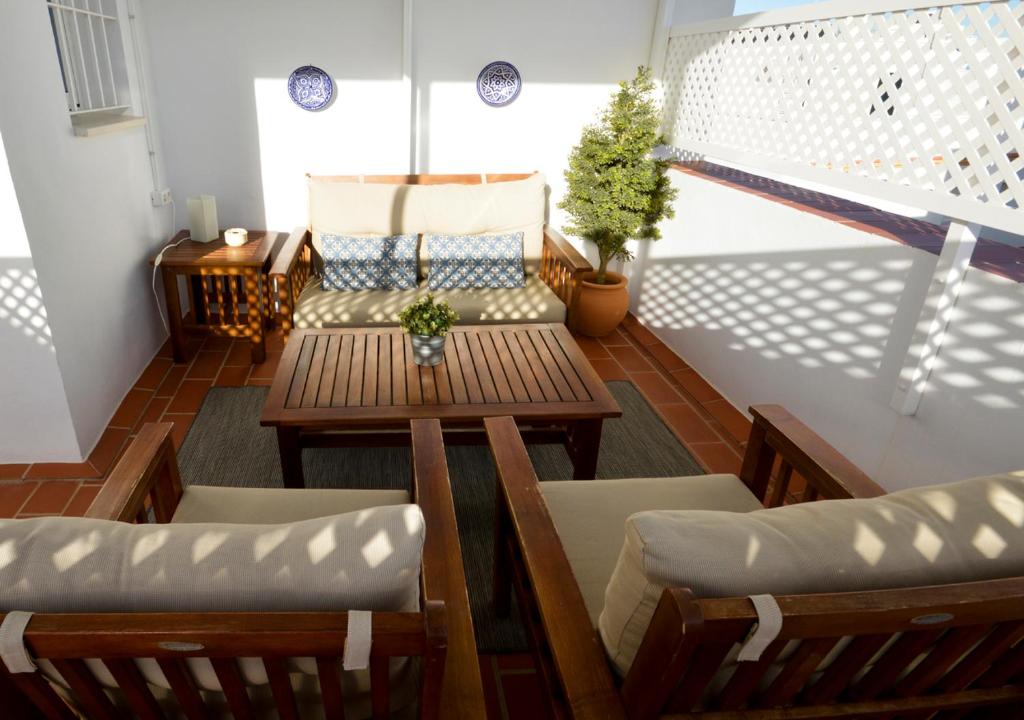 a balcony with a table and chairs and a couch at Apartamento Mariposa in Conil de la Frontera