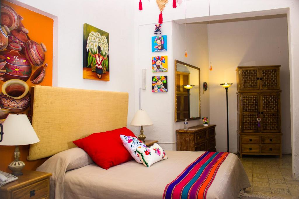 a bedroom with a bed with red pillows on it at Casona Tlaquepaque Temazcal & Spa in Guadalajara
