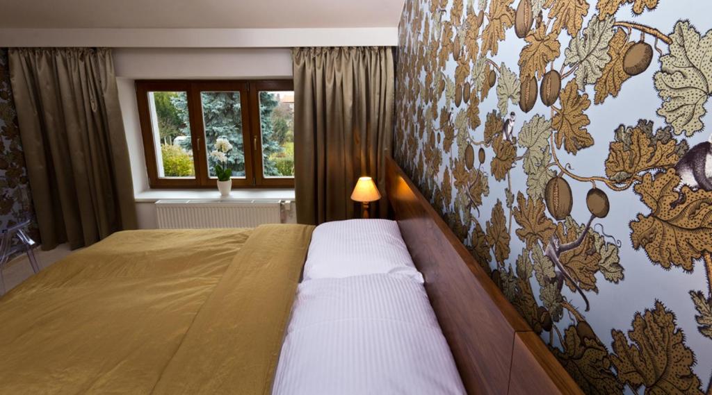 1 dormitorio con 1 cama y una pared con un mural en Residence Arx & Wellness, en Chrudim