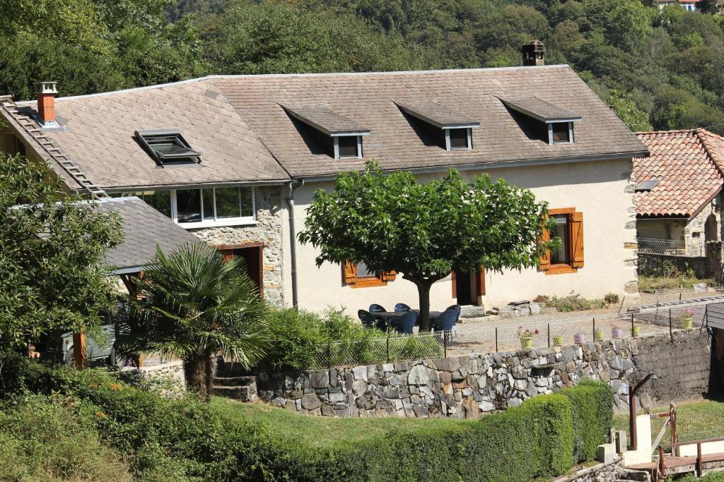 a white house with a stone wall at Maison du Coué Pyrénées Mourtis Gîte pour 2 à 12 pers in Sengouagnet