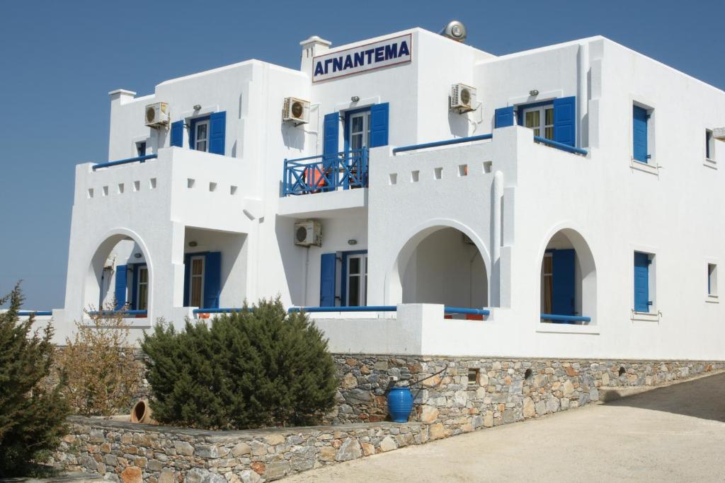 a white building with blue windows at Agnantema in Iraklia
