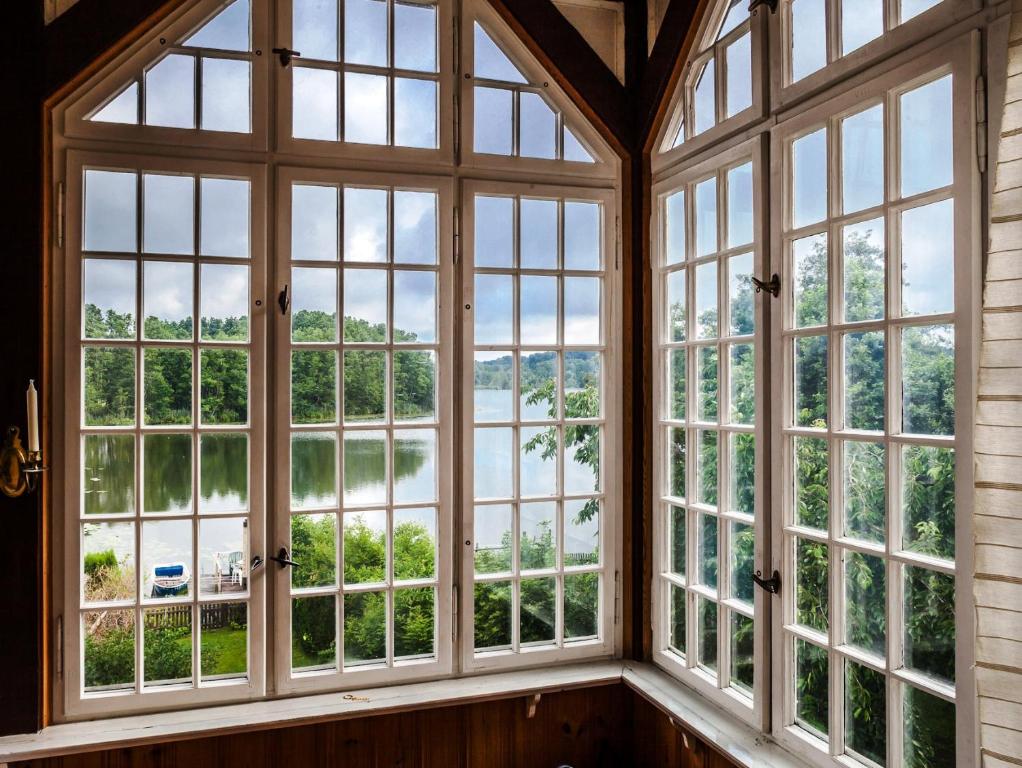リヘンにあるStilvolle Ferienwohnung am See mit Steg und eigenem Bootの水辺を望む大きな窓が備わる客室です。