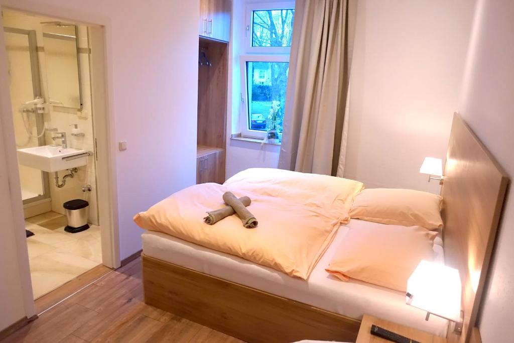 ein Schlafzimmer mit einem Bett mit einem Teddybär drauf in der Unterkunft Gasthof & Restaurant "Am Kreuz" in Essen