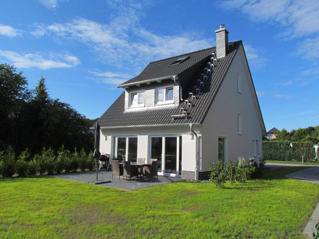 een wit huis met een gambrel dak bij Dorie in Ostseebad Sellin