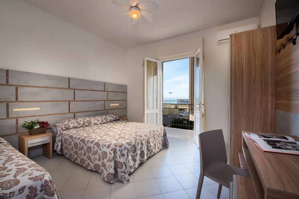 ein Hotelzimmer mit einem Bett und einem Balkon in der Unterkunft Hotel Vallechiara in Lido di Savio