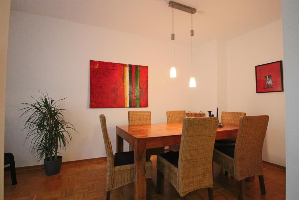 a dining room table with chairs and a painting on the wall at City-Apartment - Lüneburg Schwalbengasse in Lüneburg