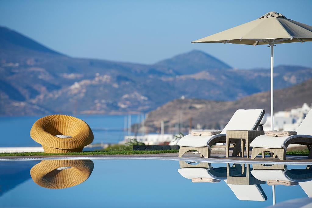 - une piscine avec des chaises et un parasol dans l'établissement Santa Maria Village Resort & Spa, à Adamas