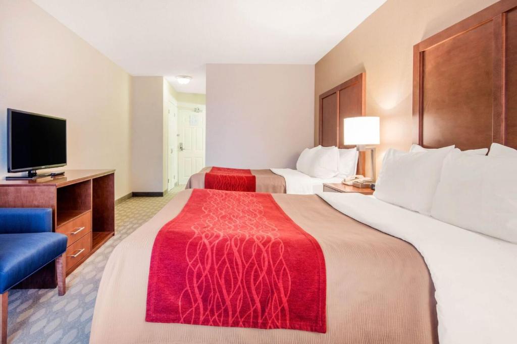 a hotel room with two beds and a flat screen tv at Comfort Inn Fallsview in Niagara Falls