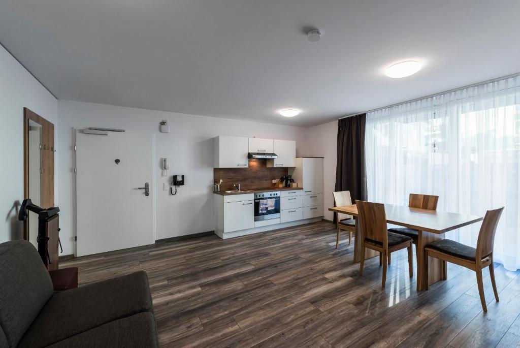 eine Küche und ein Esszimmer mit einem Tisch und Stühlen in der Unterkunft Apartments Leipziger Hof in Innsbruck