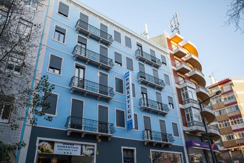 a blue building with balconies on a city street at Universo Romantico in Lisbon