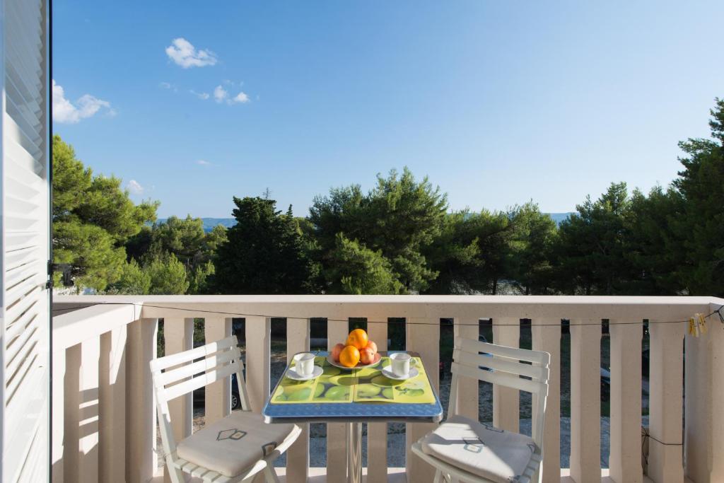 a table with a bowl of fruit on a balcony at Sun House Apartments in Bol