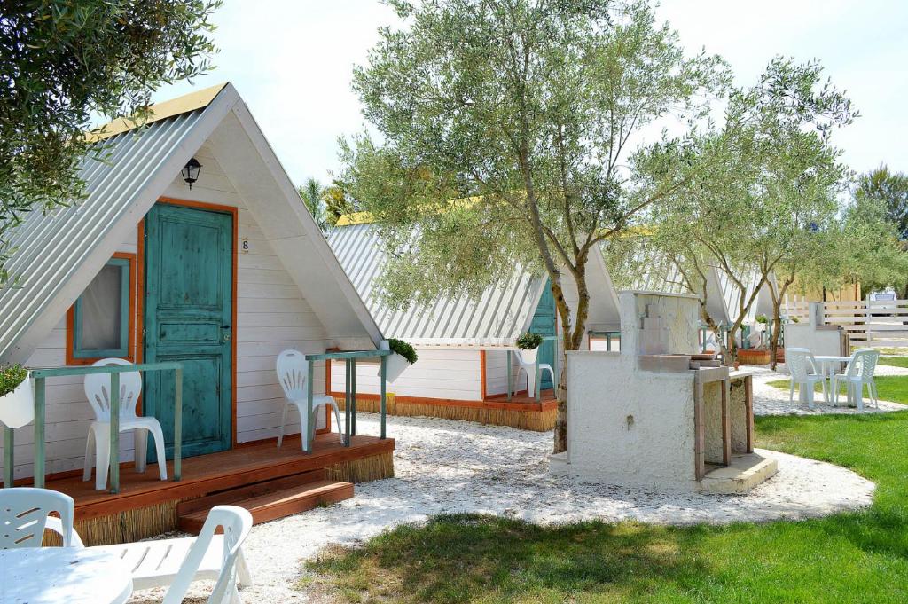 a house with a green door and white chairs at Sunseabeach in Marzamemi