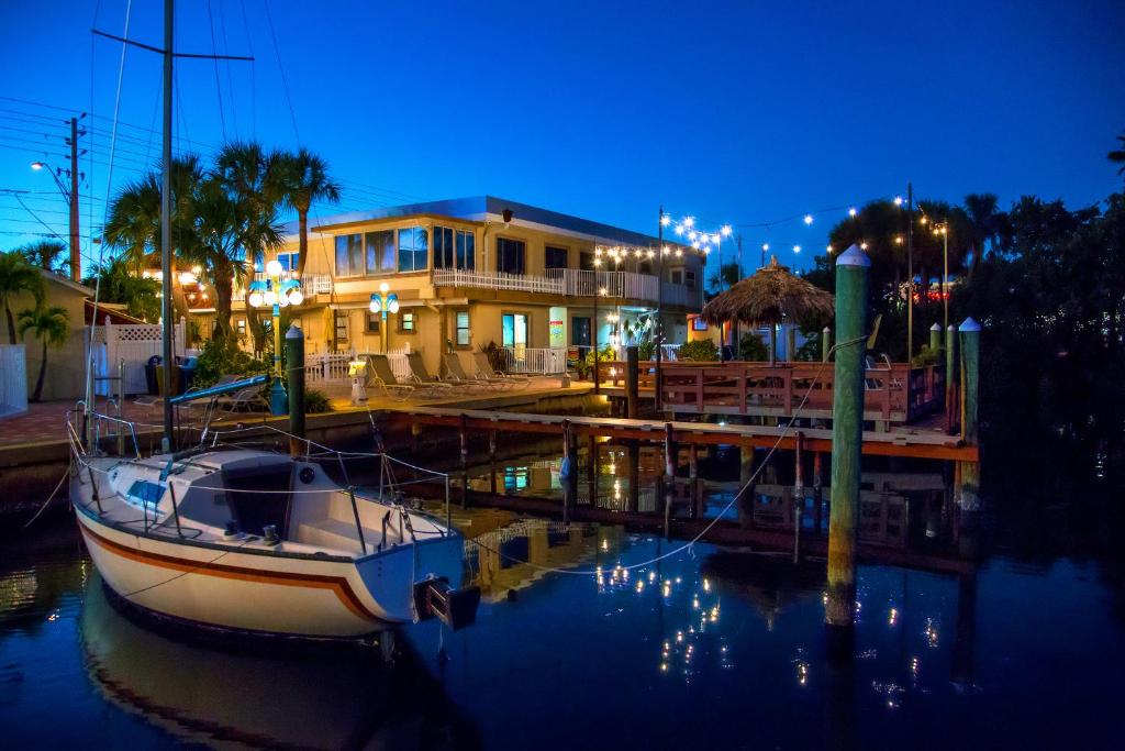 un barco atracado en un puerto deportivo frente a una casa en Bayview Plaza Waterfront Resort en St Pete Beach