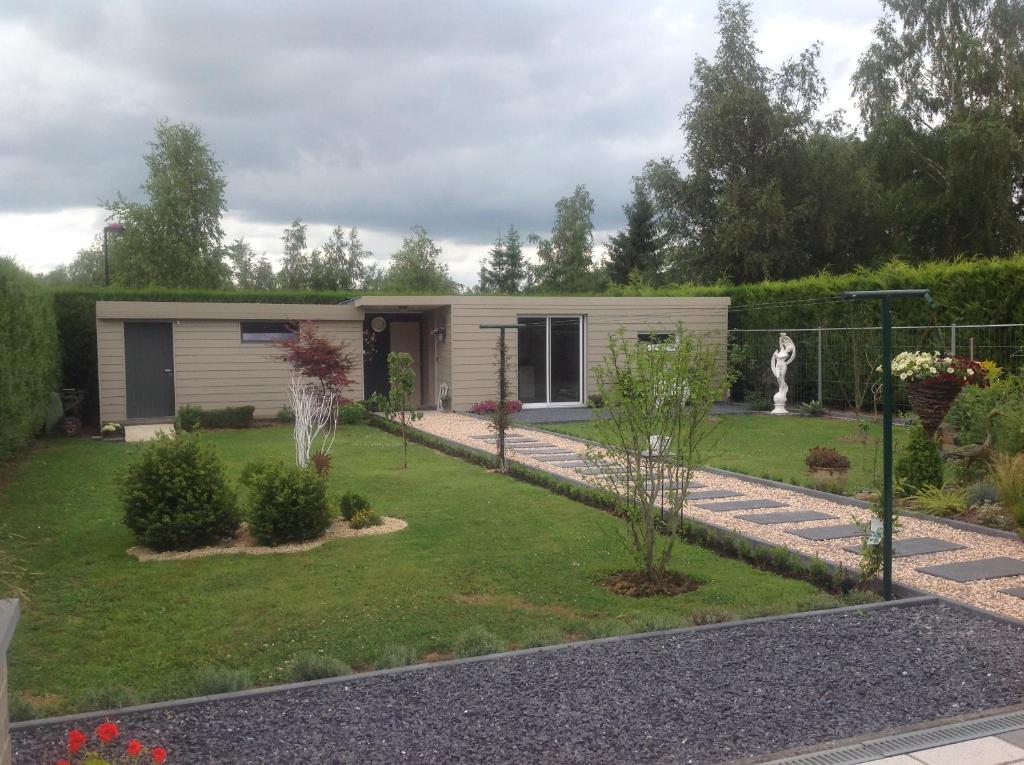 a small house in a yard with a garden at B&B Marianne in Binche