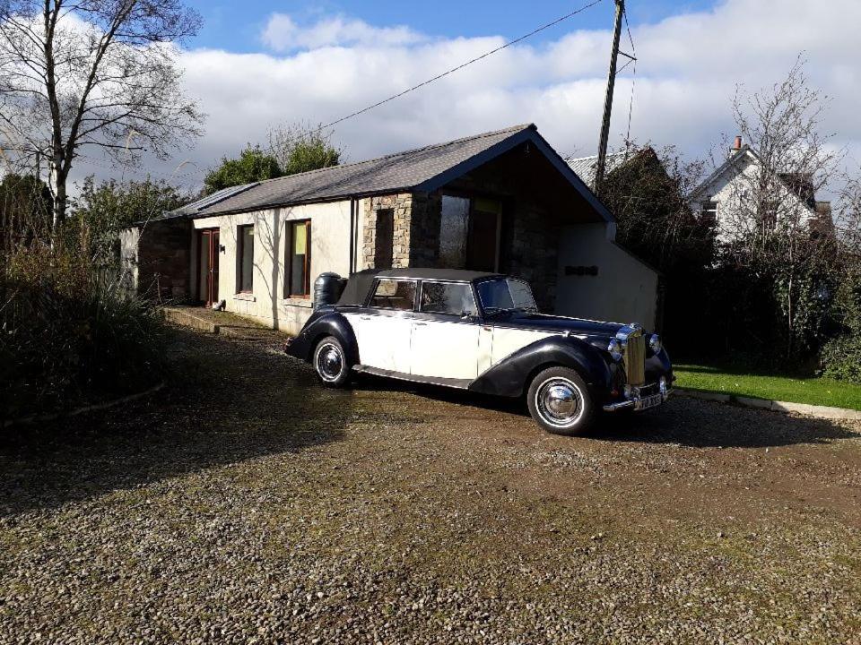 ein altes Auto, das vor einem Haus parkt in der Unterkunft Hilltop Lodge in Cultra