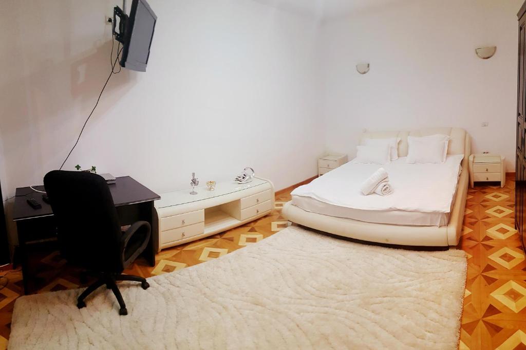 ブカレストにあるGrand Central Accomodation Sala Palatuluiのベッドルーム1室(ベッド1台、デスク、椅子付)