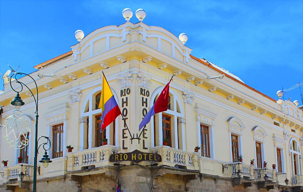 a building with two flags in front of it at Rio Hotel in Riobamba