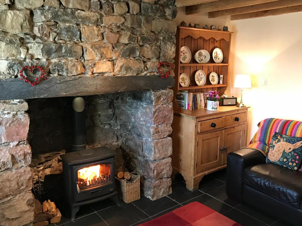 DwyranにあるWhite Lilac Cottageの石造りの暖炉付きのリビングルーム