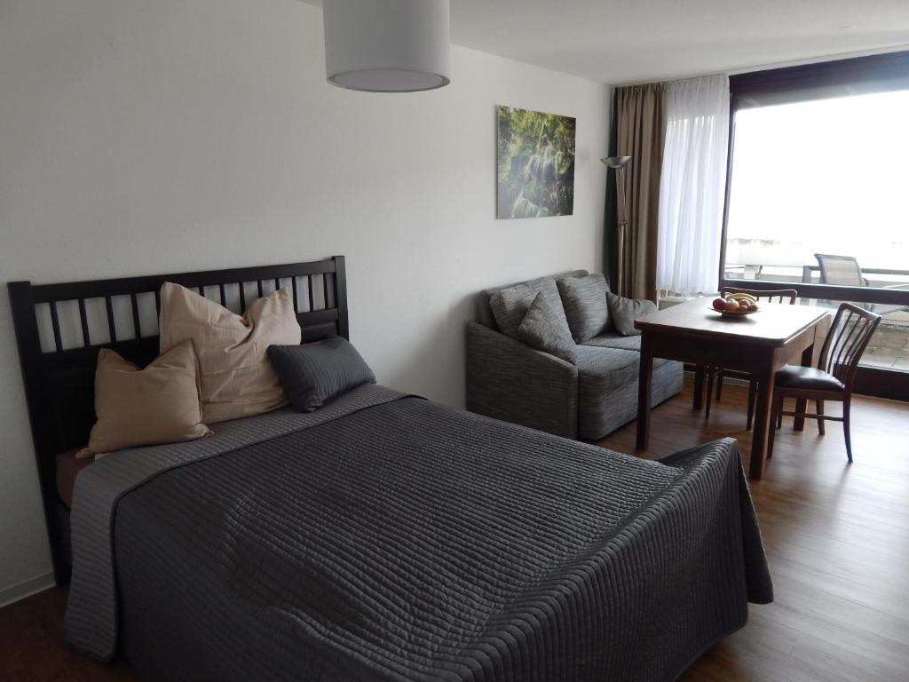 een slaapkamer met een bed en een woonkamer bij FREE Apartment - Schönblick in Bad Urach