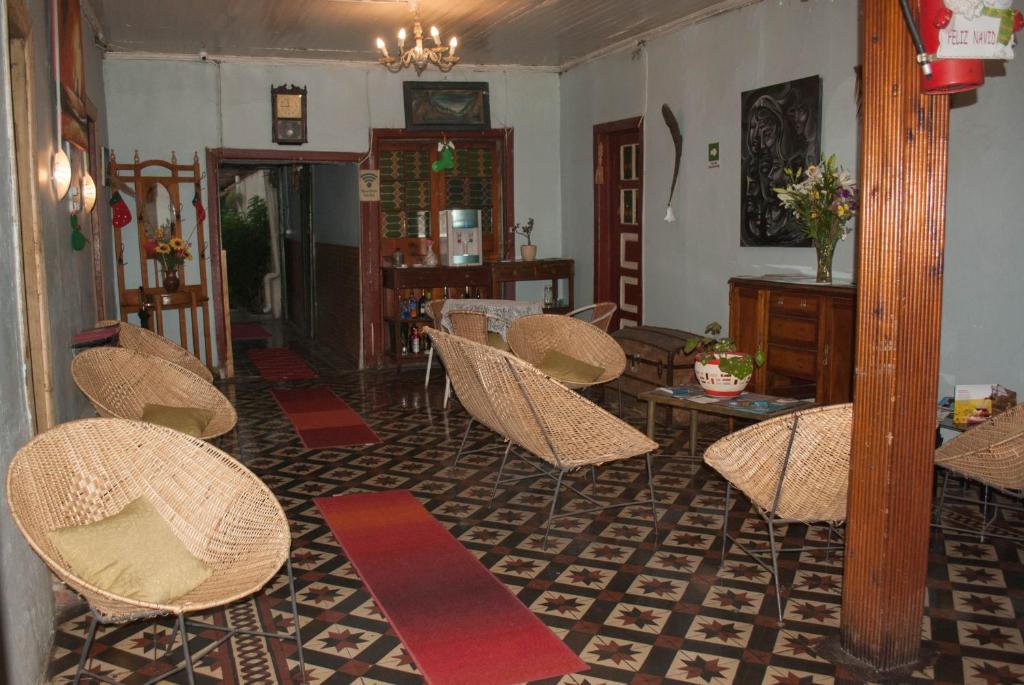 a living room with chairs and a table and a room with at Hostel 1760 in Talca