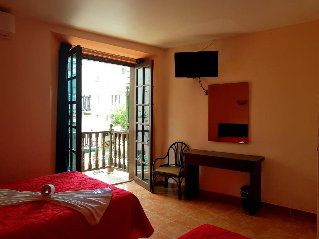 um quarto com uma cama, uma secretária e uma janela em Hotel Plaza Centro Historico em Veracruz