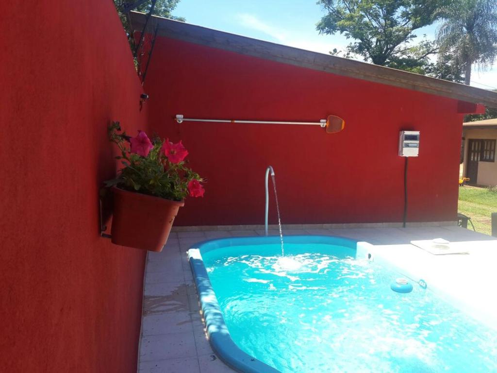 una bañera de hidromasaje en un patio trasero con una pared roja en Litoral Apart en Eldorado
