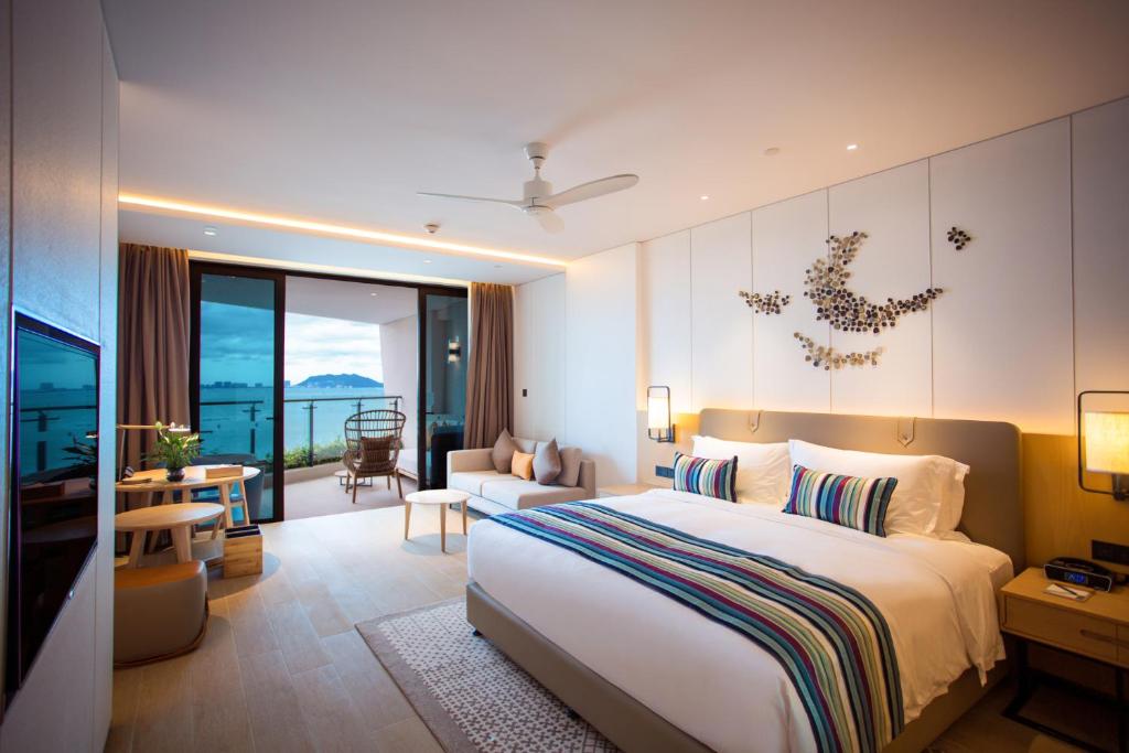 ein Hotelzimmer mit Bett und Wohnzimmer in der Unterkunft Sanya Conifer Resort in Sanya
