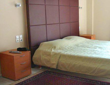 - une chambre avec un lit et une commode en bois dans l'établissement Art Suites Athens, à Athènes