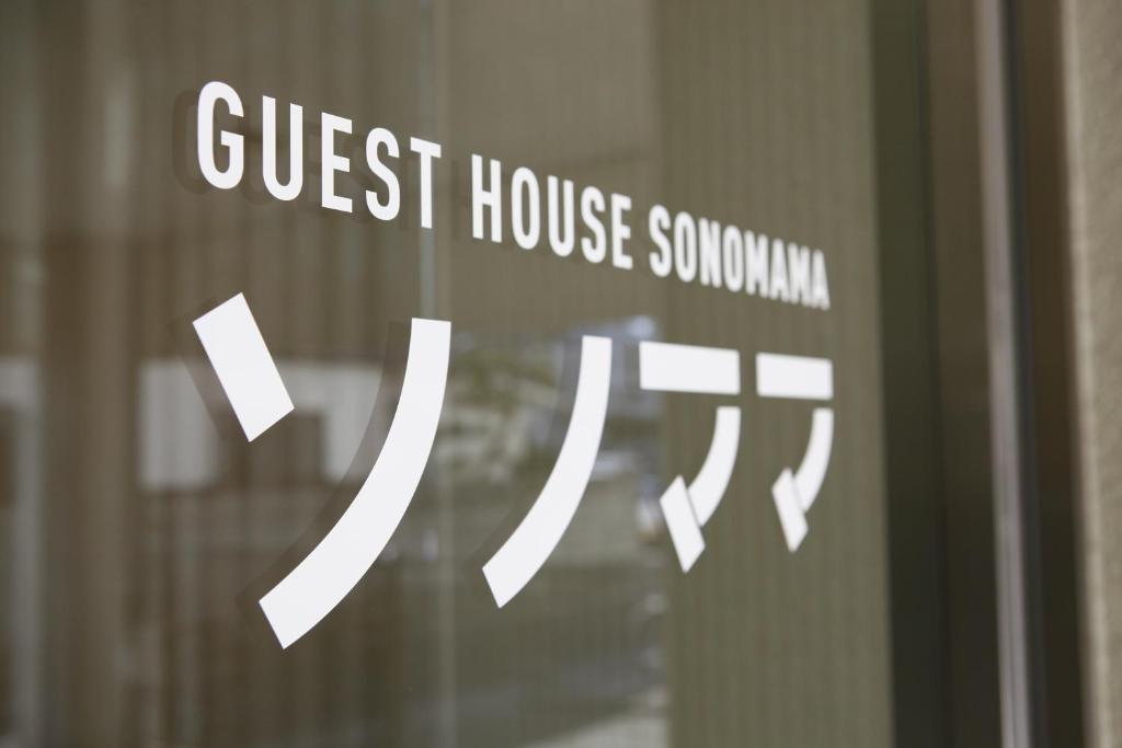 甲府市にあるゲストハウスソノママのゲストハウス症候群の看板付きのガラスドア