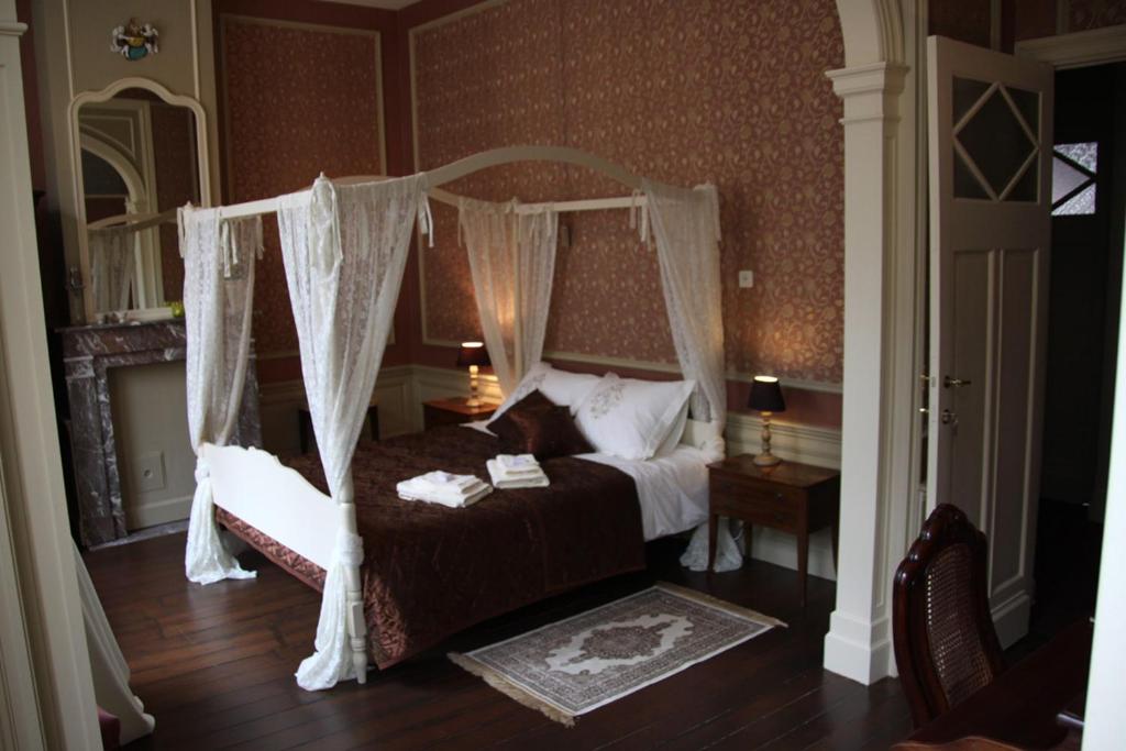 a bedroom with a bed with a canopy at La Porte Cochère in Ieper