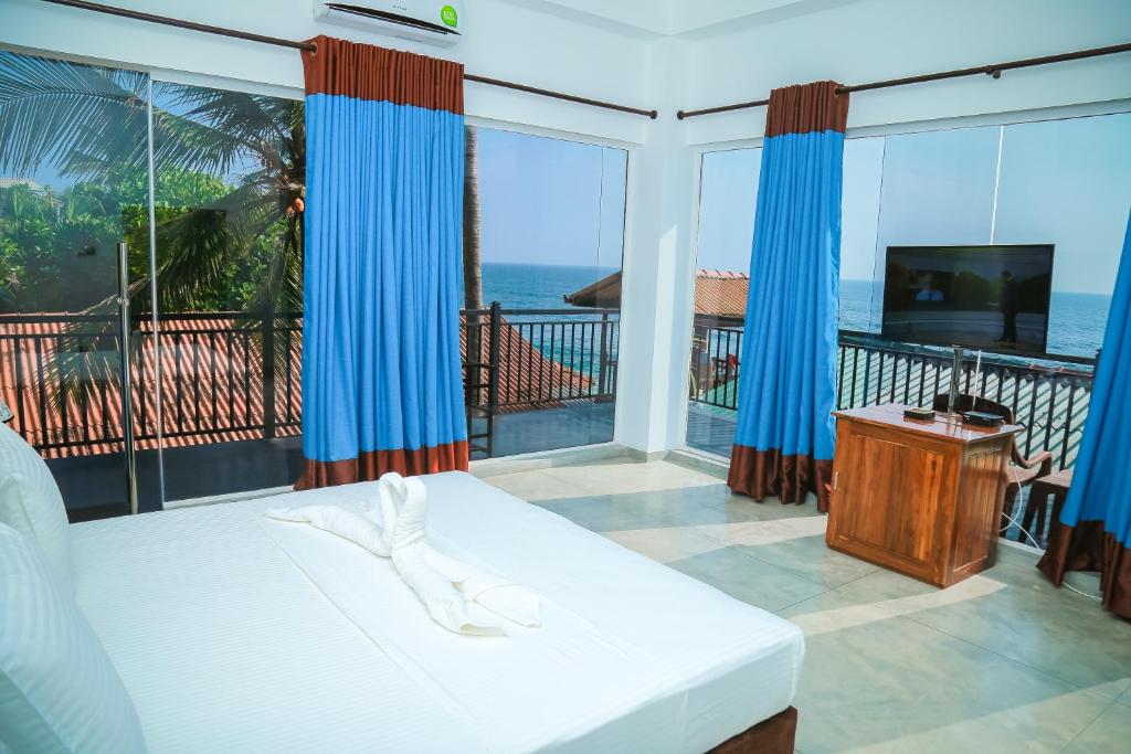 a bedroom with a bed and a view of the ocean at Funky Hotel in Hikkaduwa