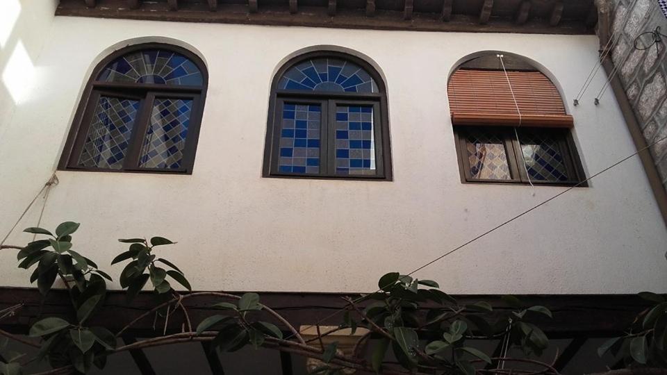a house with three windows and a plant at Casa Cossio in Jaén