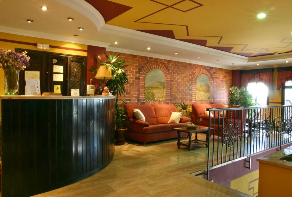 eine Lobby mit Sofas und eine Bar in einem Gebäude in der Unterkunft Hotel Las Rosas in Priego de Córdoba