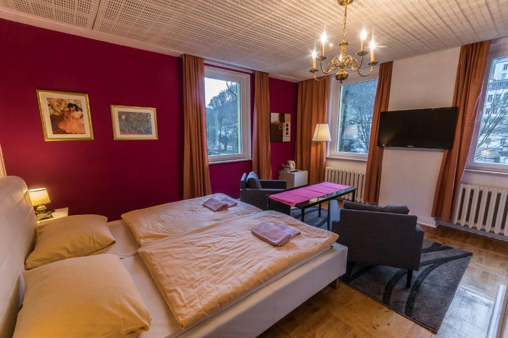 een slaapkamer met een bed en een tafel en stoelen bij Pension Menge in Bad Schandau