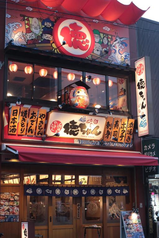 a building with a sign on the front of it at Guesthouse COCO Hiroshima (Female Only) in Hiroshima