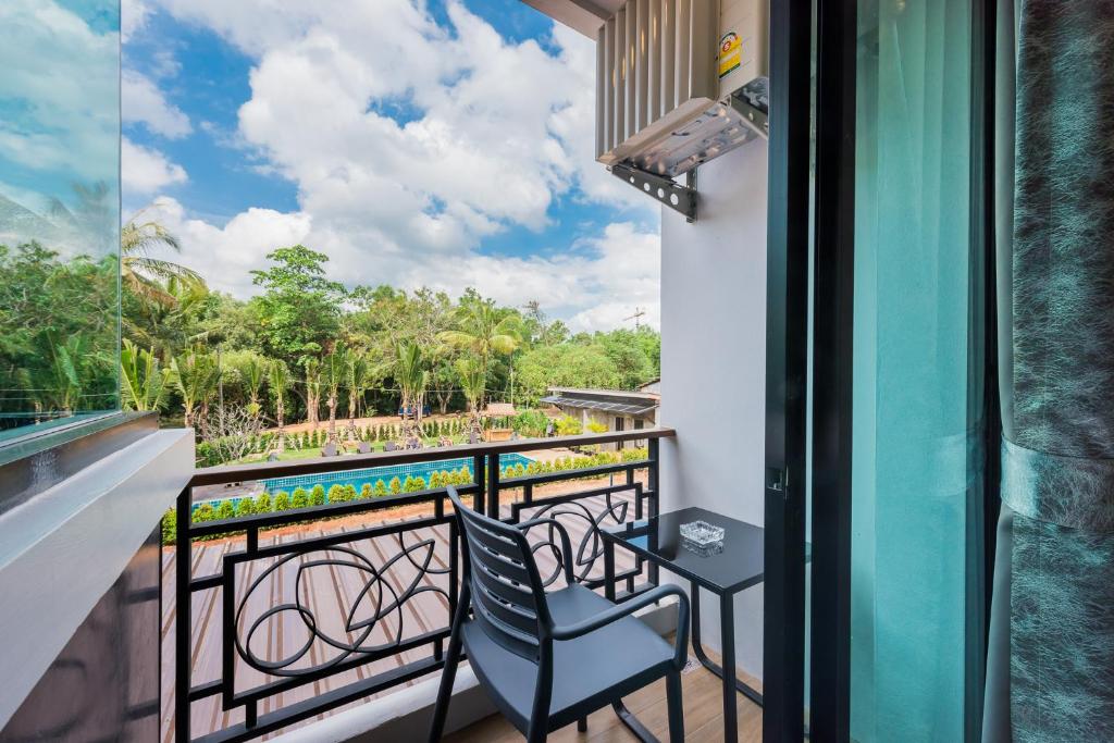 a balcony with a chair and a table and a view at River Front Krabi Hotel in Krabi