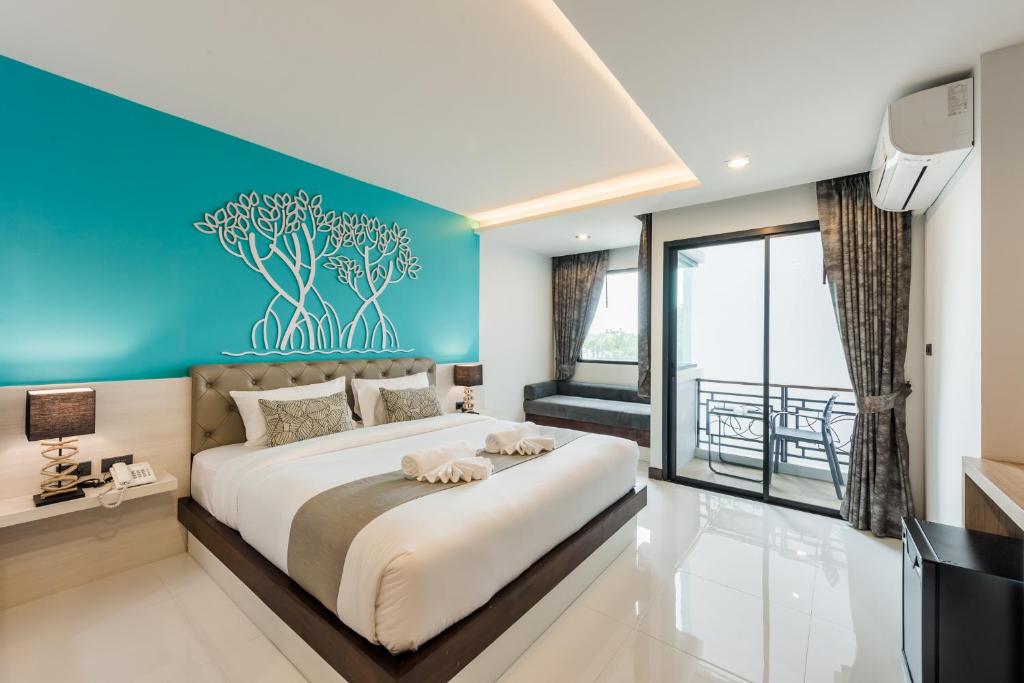 a bedroom with a large bed with a blue wall at River Front Krabi Hotel in Krabi