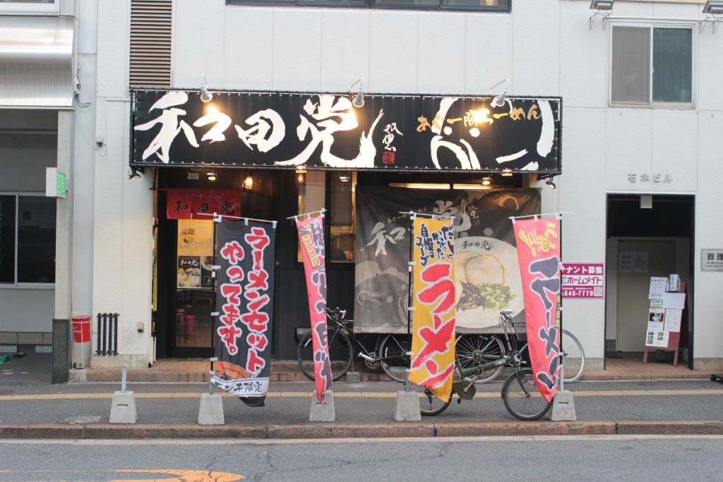 a store with a bike parked in front of a building at Guesthouse COCO Hiroshima (Female Only) in Hiroshima