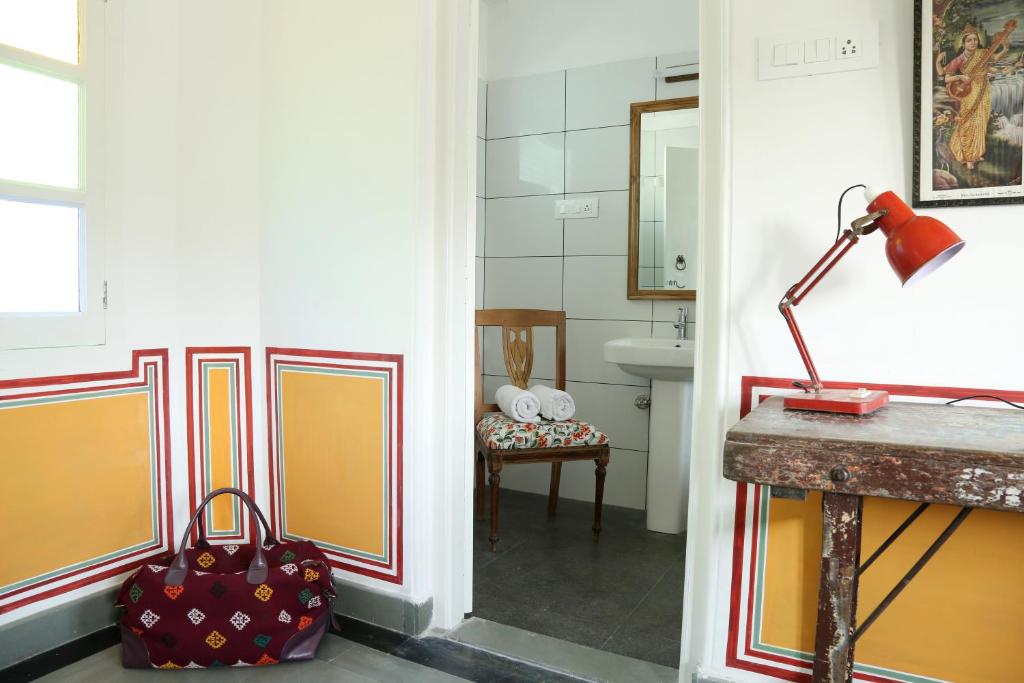 a hallway with a bathroom with a luggage bag at Little Garden Guest House in Udaipur