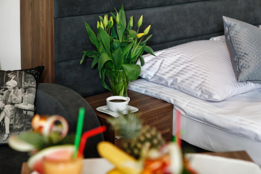 Un dormitorio con una cama y una mesa con un jarrón de flores en Jerry Apartment, en Jastrzębia Góra
