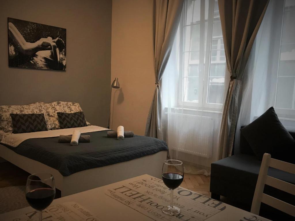 sypialnia z łóżkiem i stołem z 2 kieliszkami wina w obiekcie Apartments Poland Kazimierz w Krakowie