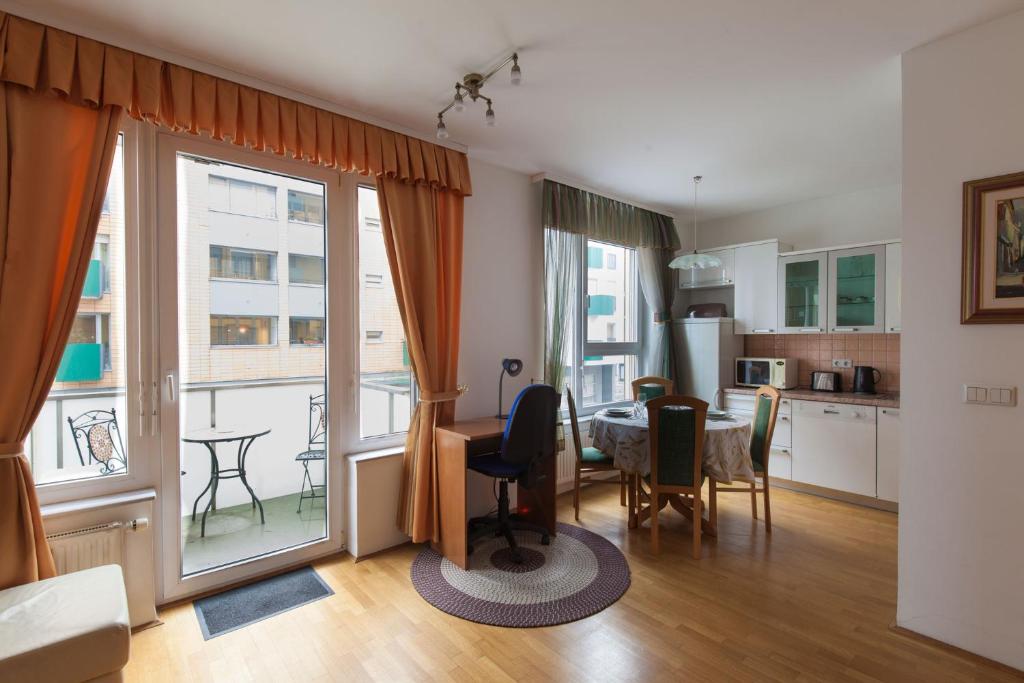 sala de estar con mesa y cocina con ventana en Central Apartment Anita Tour As Ljubljana, en Liubliana
