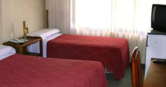 a hotel room with two beds and a television at Hotel City in Trelew