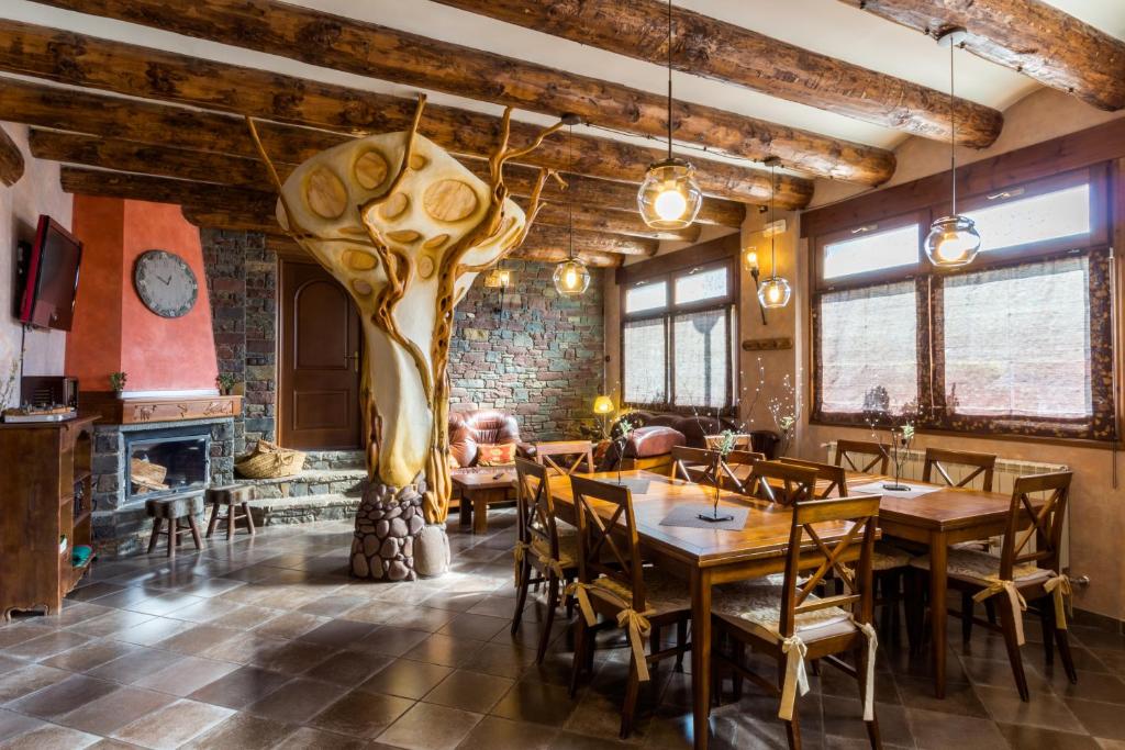 une salle à manger avec des tables, des chaises et une cheminée dans l'établissement Hotel Flor De Neu, à El Pont de Suert
