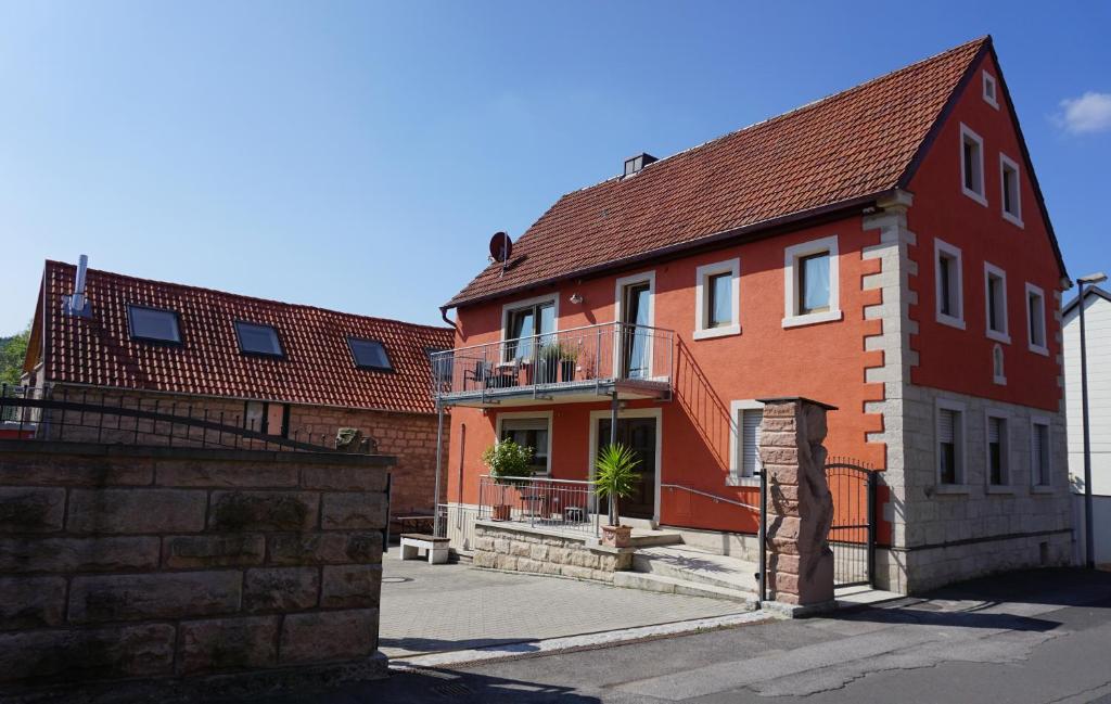 a red brick house with a balcony on a street at Atelier Reinhart in Rauhenebrach