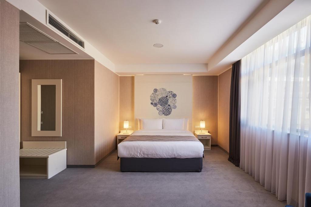 Postel nebo postele na pokoji v ubytování Gallery Palace Hotel